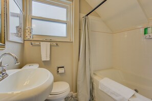 Une salle de bain avec un lavabo, des toilettes et une baignoire.