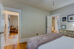 Une chambre à coucher avec un lit, une commode et des œuvres d’art accrochées au mur.