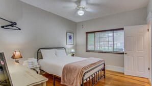 A bedroom with a bed, bedside lamps, a ceiling fan, a window with blinds, and a door. - 3BR Hot-tub & Dog-friendly Old Colorado City!! (Colorado Springs)