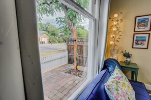 Quarto com vista para um quintal, cerca de madeira e um banco.