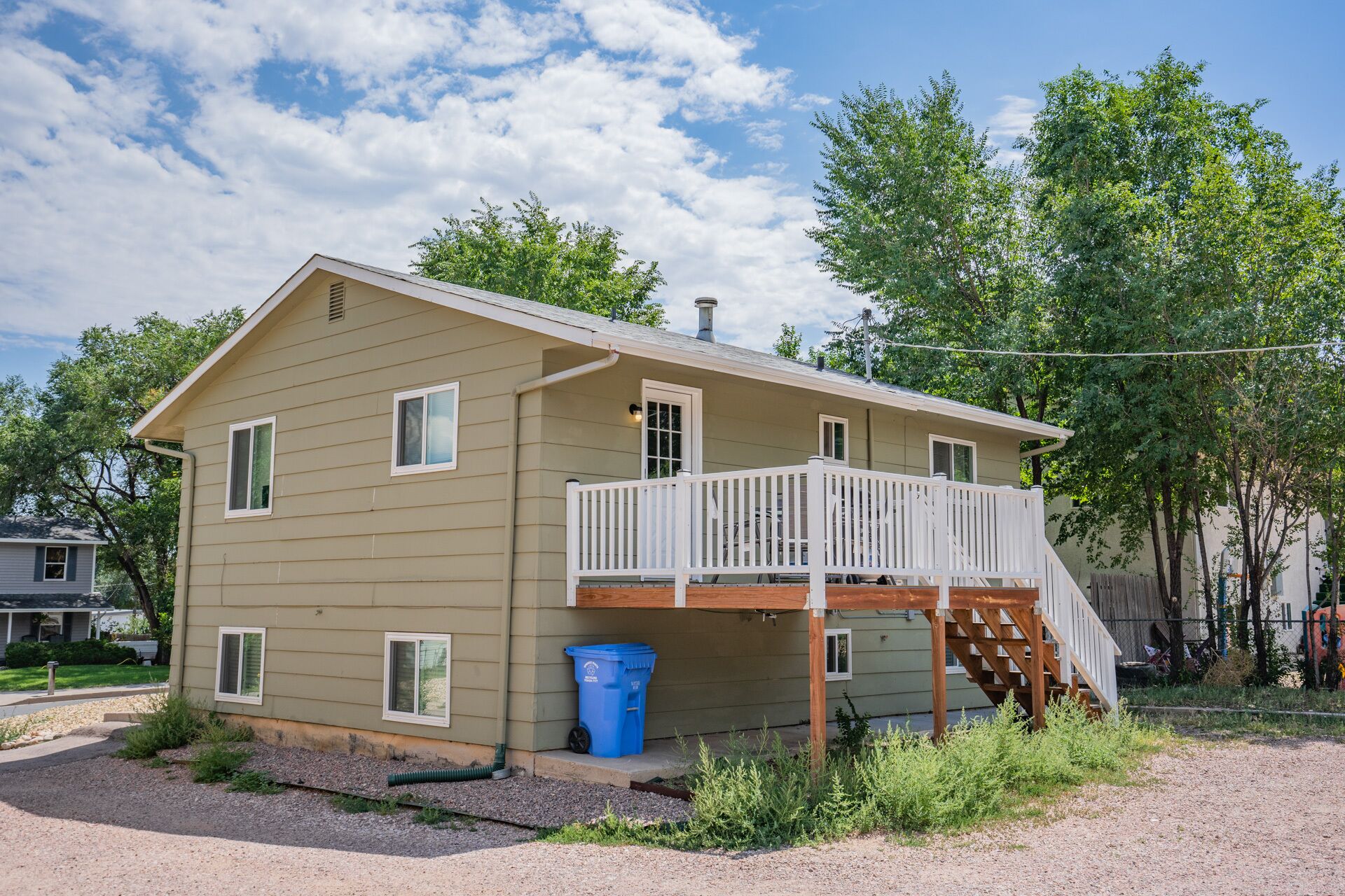 A two-story house with a front porch and a small deck.