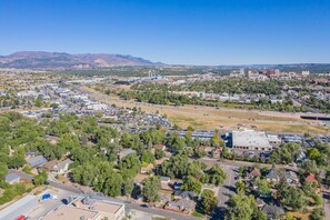 An aerial view of a suburban area with residential houses, a large parking lot, and industrial buildings in the background. - 4BD Luxuryclose to Downtown3ba & Pet-friendly!! (Colorado Springs)