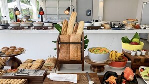 A buffet setup with various food items, including bread, pastries, fruits, and vegetables. - Luxurious Four Seasons PR Bahia Beach Villa; Golf, Pool, Tennis & Golf Cart (Río Grande)