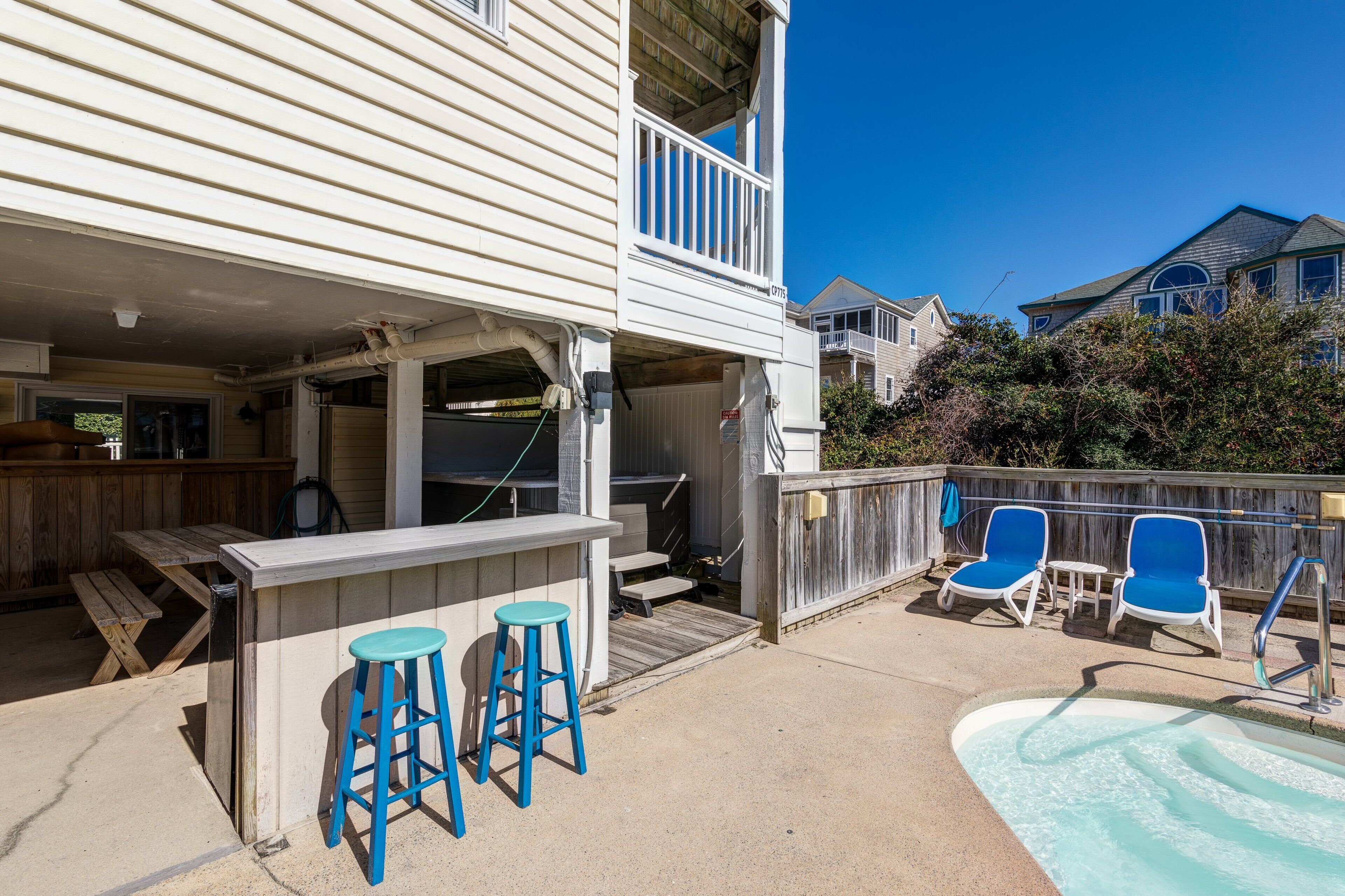 Un jardin avec une piscine, un espace barbecue et une terrasse en bois.