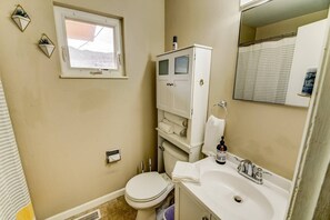 A compact bathroom with a toilet, sink, and cabinet. - 2BR Hikers Dream Red Rocks Dog-friendly! (Colorado Springs)
