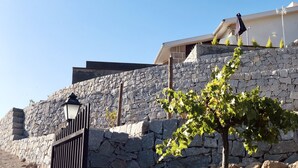 A stone wall with a gate and a lamp post. - BHDouro (Baiao)