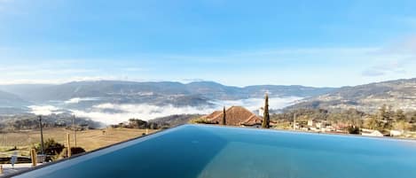 Una piscina al aire libre, sillones reclinables de piscina