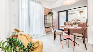 Un comedor moderno con una mesa redonda, sillas y una planta en maceta.