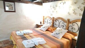 A neatly made bed with striped bedding and pillows, a wooden headboard, and a wall with butterfly decorations.