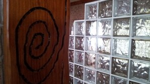 A wooden wall with a circular design and a window with frosted glass panels.
