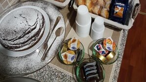 Un buffet de petit-déjeuner proposant un assortiment de viennoiseries, de pains et de boissons.
