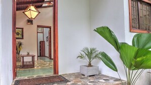 A stone-floored entrance with a wooden door, a potted plant, and a hanging light fixture. - Villa 4 - Amazing 2 Bed Villa with Private Garden, Playa Chiquita (Limón)