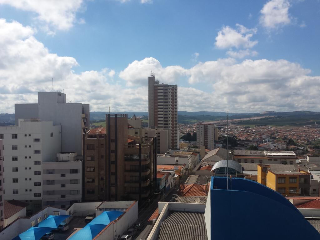 Paisagem urbana com diversos edifícios, incluindo um arranha-céu e várias construções mais baixas.