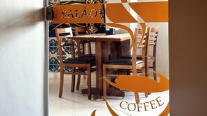 Een deur met een glazen paneel waarop 'SALÃO' en 'COFFEE' staat.