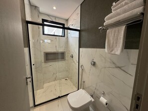 Premium kamer | Badkamer | Een douche, handdoeken, zeep, toiletpapier