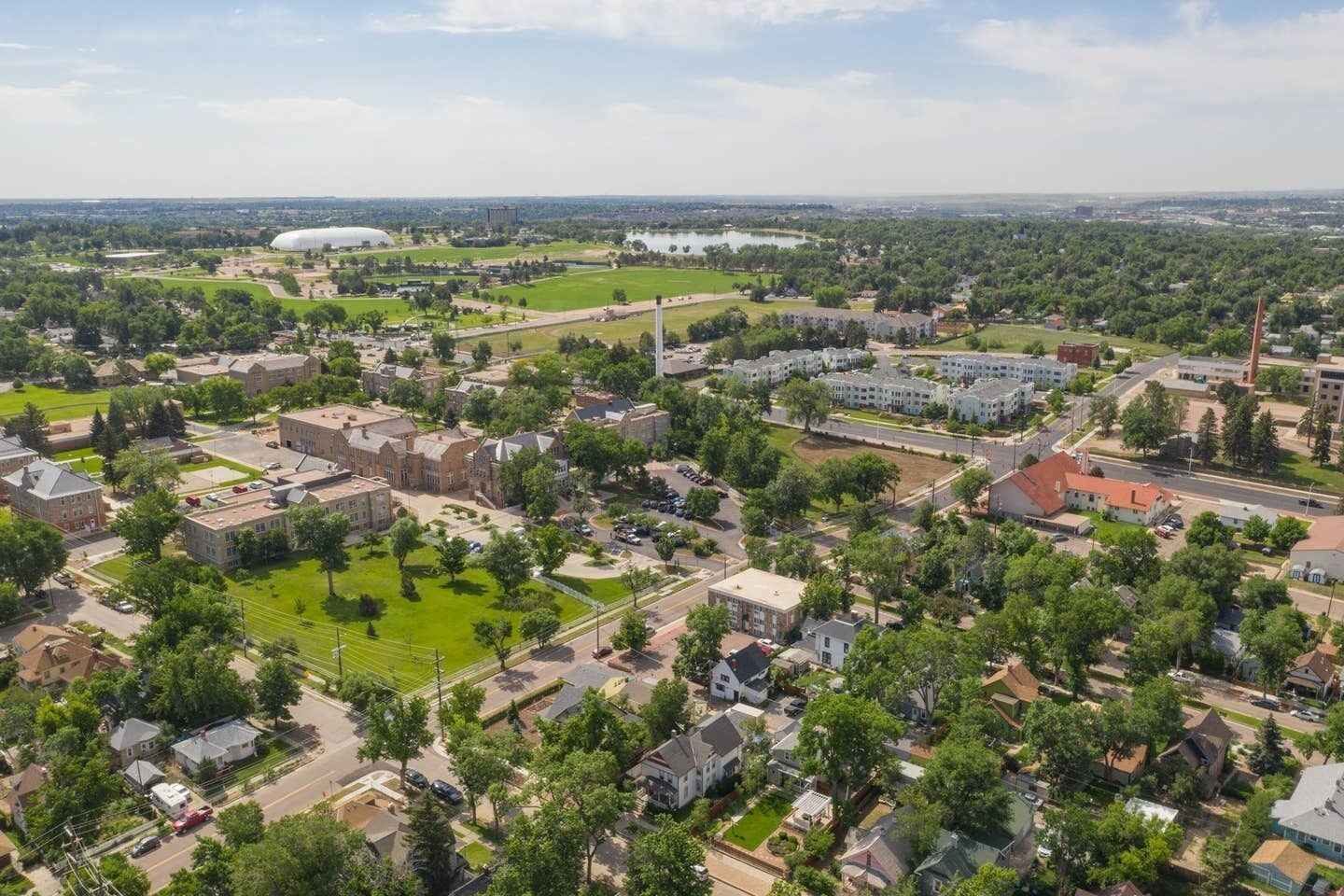 An aerial view of a campus with multiple buildings, green spaces, and a large dome structure.