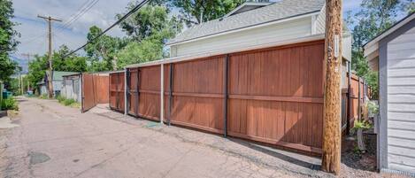 A residential area with a long wooden fence, a garage, and a house with a sloped roof.