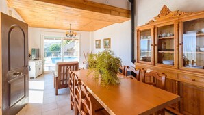 A dining area with a wooden table, chairs, and a cabinet with glass doors.