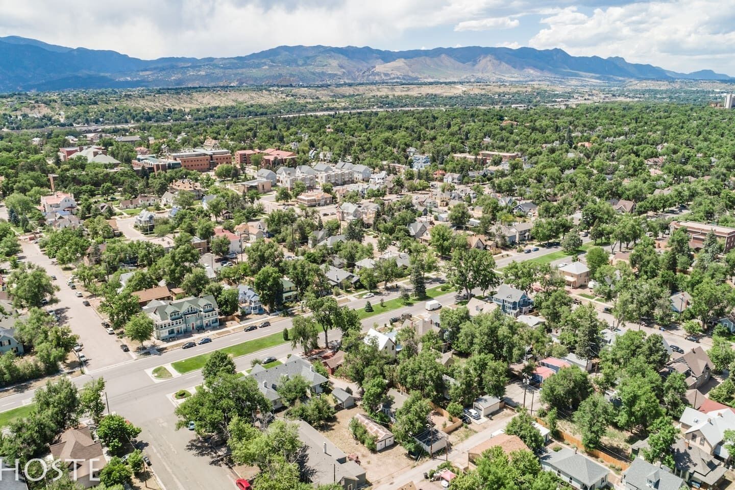 An aerial view of a residential area with houses, roads, and greenery.