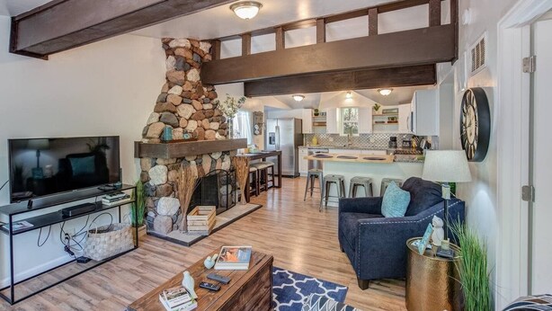 A modern living room with a stone fireplace, a flat-screen TV, and a cozy seating area. - 2brcheyenne Cañon Minutes to Hiking and Zoo (Colorado Springs)