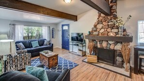 A living room with a stone fireplace, a sofa, a coffee table, and a TV. - 2brcheyenne Cañon Minutes to Hiking and Zoo (Colorado Springs)