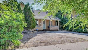 A single-story house with a covered porch, a gravel driveway, and a well-maintained lawn.