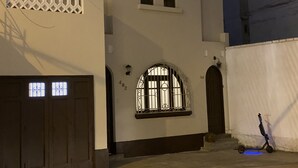 A building with a white facade, two arched windows, and a door with barred windows. - Vintage Home near Larcomar (Urb Cercado de Miraflores)