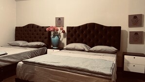 A bedroom with two beds, a nightstand with a vase of flowers, and framed artwork on the wall. - Vintage Home near Larcomar (Urb Cercado de Miraflores)