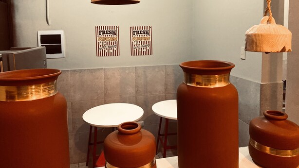 A room with large copper pots, a hanging light fixture, and two small white tables. - Vintage Home near Larcomar (Urb Cercado de Miraflores)