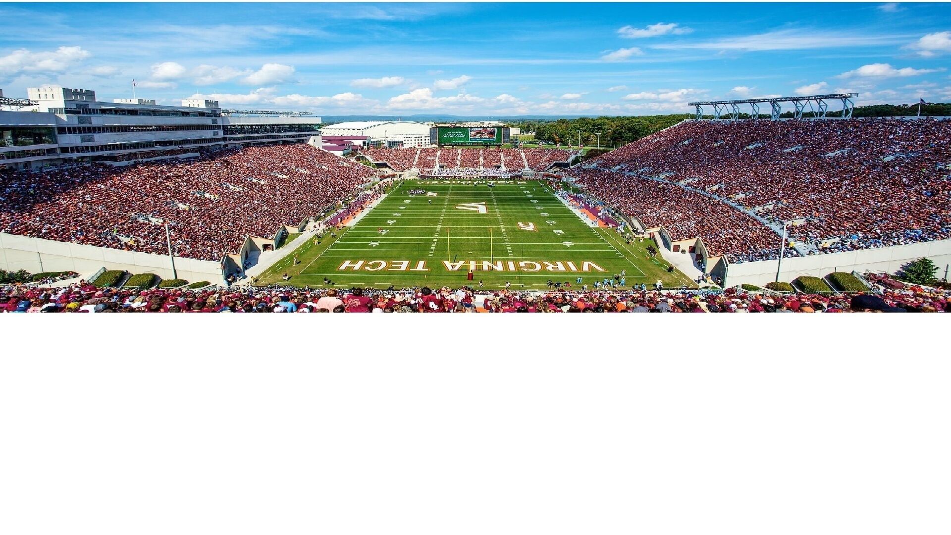 A stadium with a football field, surrounded by spectator stands.