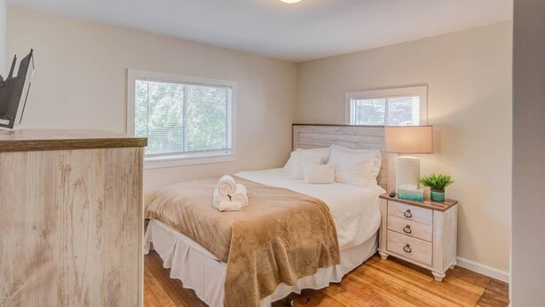 A bedroom with a bed, bedside table, lamp, and a window. - 3brdowntownwalk to Everywhere & Bars W/fire pit (Colorado Springs)