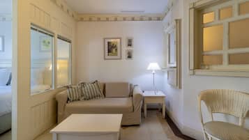 Une pièce comprenant un canapé, une petite table, une chaise, une lampe et une fenêtre donnant sur un beau paysage.