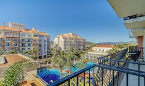 Un resort con piscina, varias construcciones y vista a las montañas.