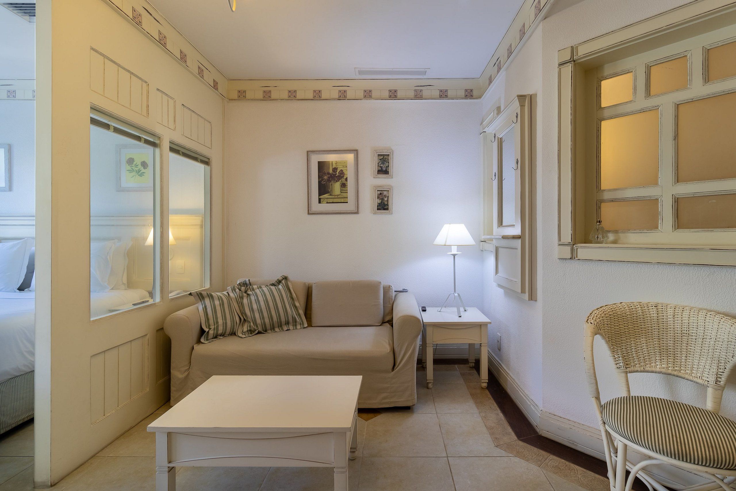 Une pièce comprenant un canapé, une petite table, une chaise, une lampe et une fenêtre donnant sur un beau paysage.