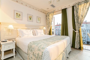 A hotel room with a large bed, two bedside tables, a window with curtains, and framed floral artwork on the wall. - Confortáveis Studios no IL Campanario Resort ILCJR (Florianópolis)