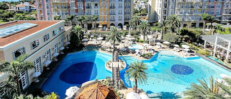 Una piscina al aire libre, sombrillas, sillones reclinables de piscina