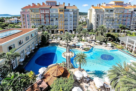 Una piscina al aire libre, sombrillas, sillones reclinables de piscina