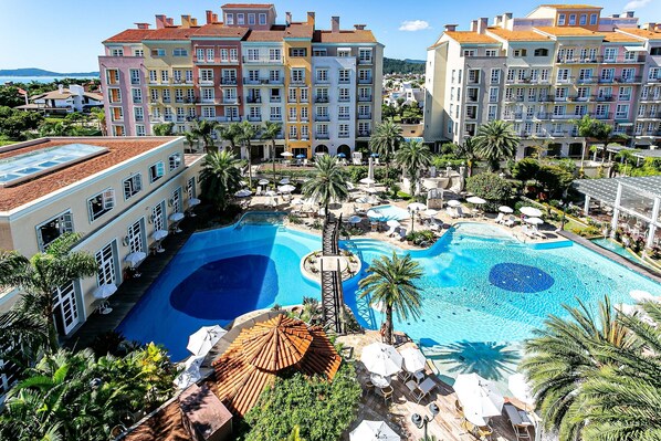 Una piscina al aire libre, sombrillas, sillones reclinables de piscina
