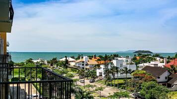 A residential area with houses, a balcony, and a view of the sea.