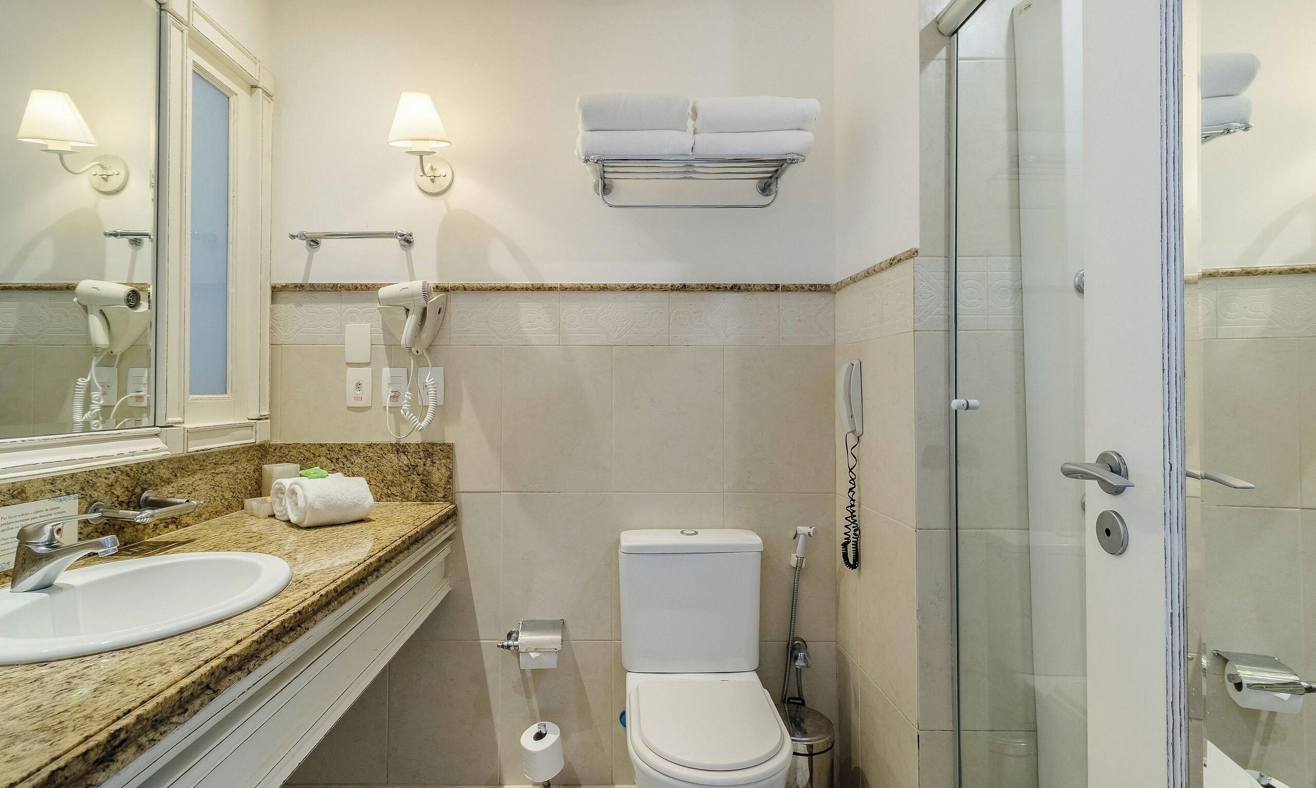 Een badkamer met een wastafel, toilet en douche.