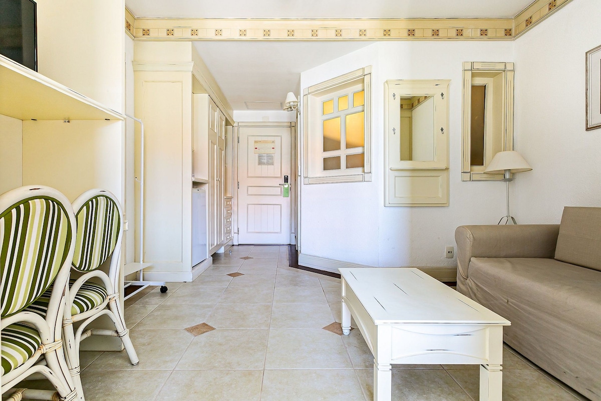 A hallway with a white sofa, a white table, and striped chairs.