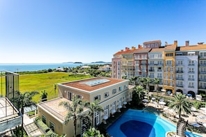Un hotel con piscina, vistas al mar y una terraza en la azotea.