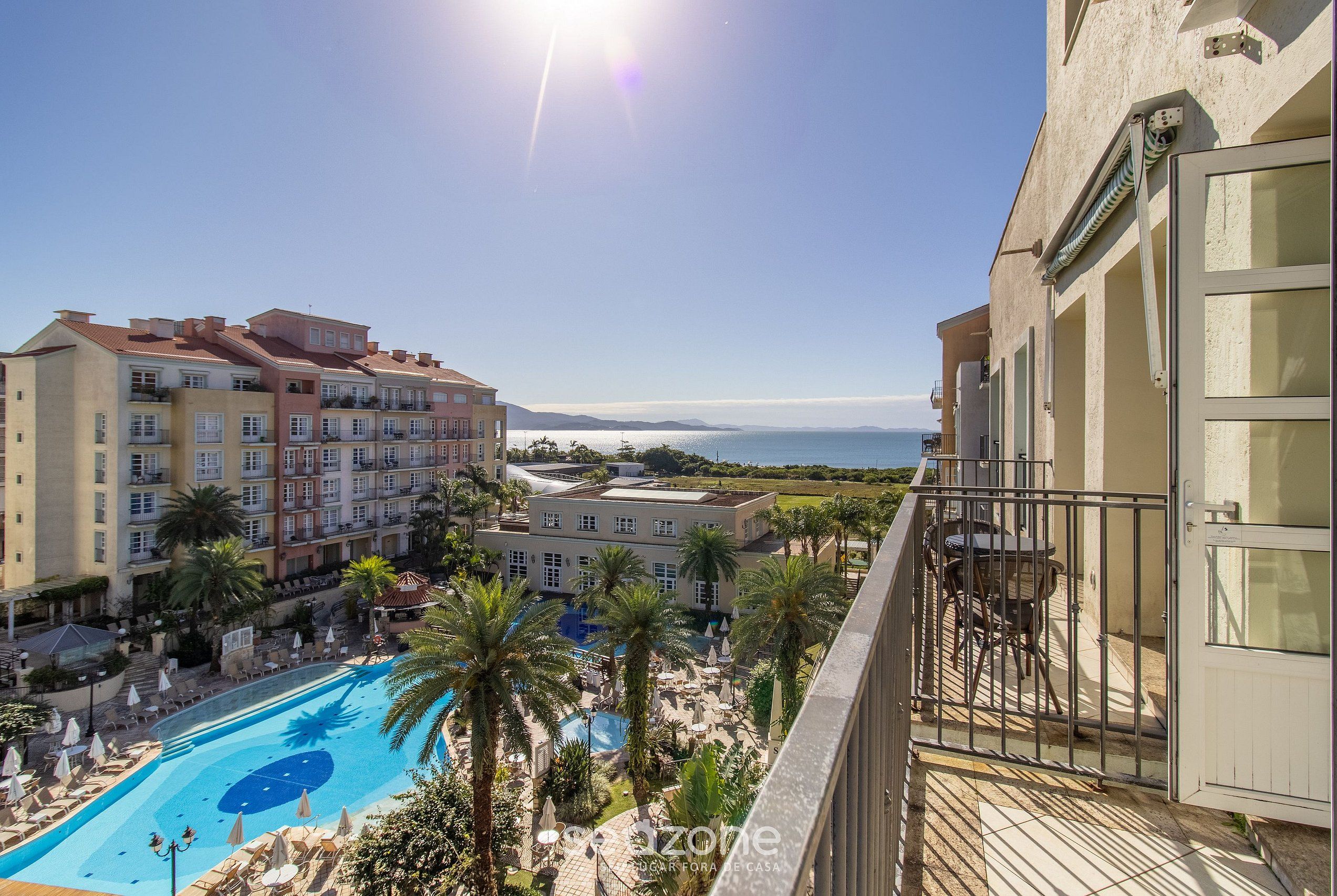 Un hotel con piscina, varias edificaciones y vista al mar.