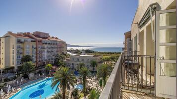 Un hotel con piscina, varias edificaciones y vista al mar.
