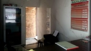 A room with a marble wall, a white pendant light, a small table with a notebook, and a poster listing prices.