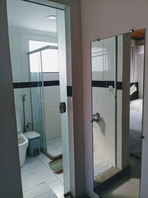 Een douche, handdoeken, zeep, toiletpapier