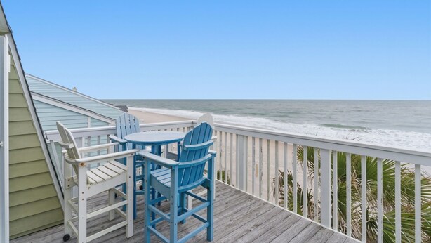 A wooden deck with a table and chairs, overlooking the ocean. - OD 2103C Top Floor Oceanfront Condo, elevator, Indoor/Outdoor Pools (Kure Beach)