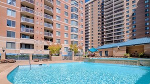 Piscina rodeada por un edificio de ladrillo con varios balcones.