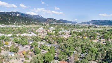 A town with a mix of residential and commercial buildings, surrounded by mountains and greenery.