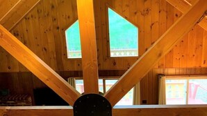 Un interior de madera con techo alto y armaduras triangulares.